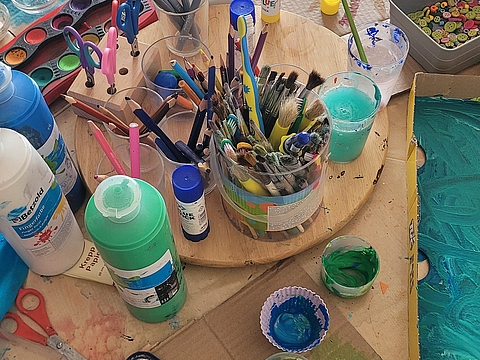 Eine bunte Sammlung von Bastelutensilien und bemalten Pappen 